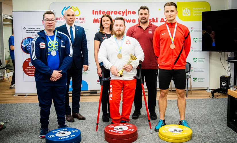 Czterech uczestników (oraz Prorektor ds. studenckich i trener) Integracyjnych Mistrzostw Polski AZS w podnoszeniu ciężarów dla osób z niepełnosprawnościami prezentują zdobyte medale.