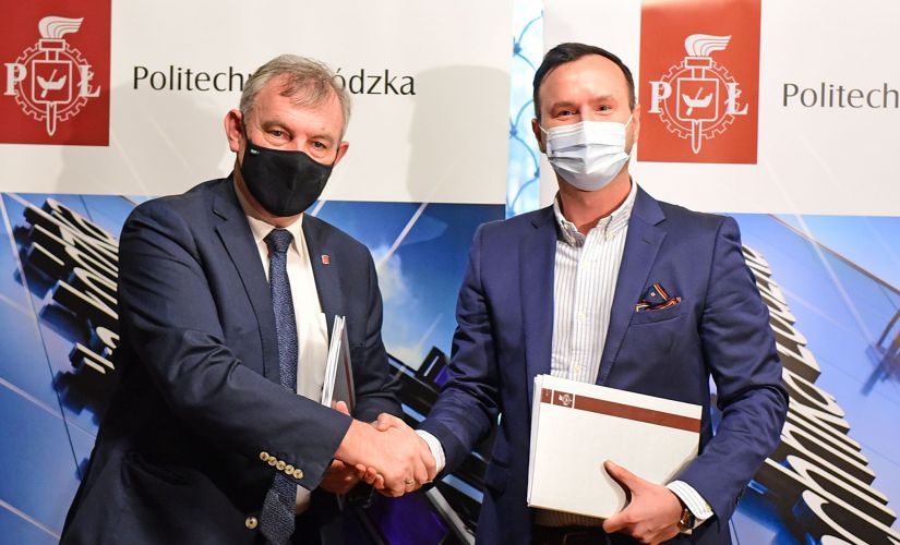Sygnatariusze umowy (od lewej): rektor prof. Krzysztof Jóźwik i prezes Marek Gajewski stoją na tle firmowych roll upów.