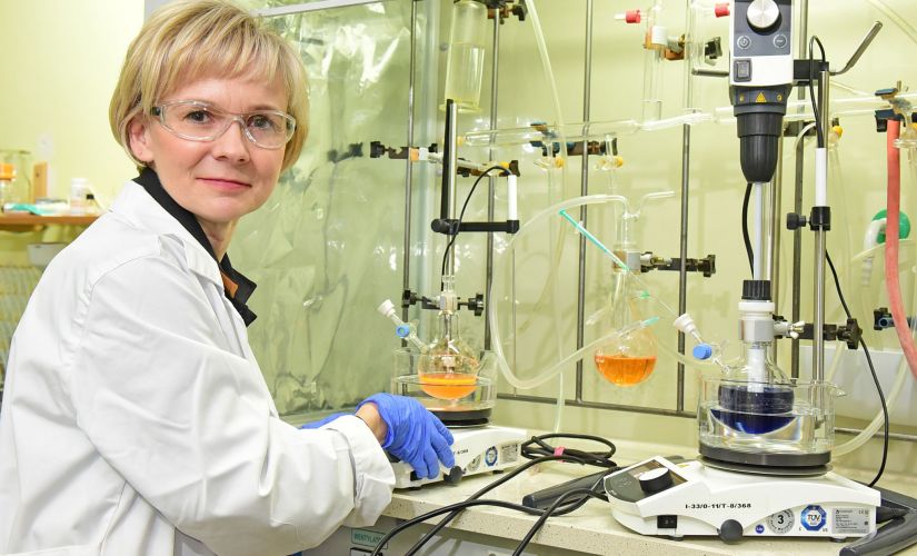 Prof. Joanna Pietrasik z Wydziału Chemicznego PŁ w białym fartuchu przy stanowisku laboratoryjnym.