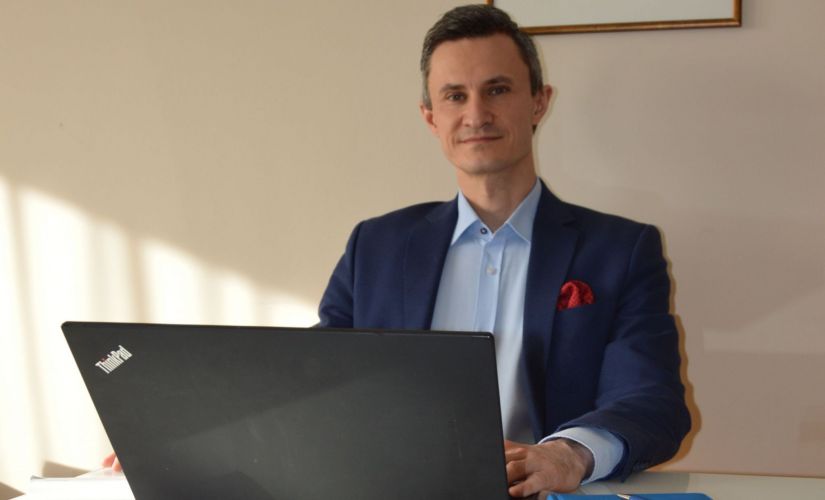 Rafał Byczkowski przy biurku z laptopem.