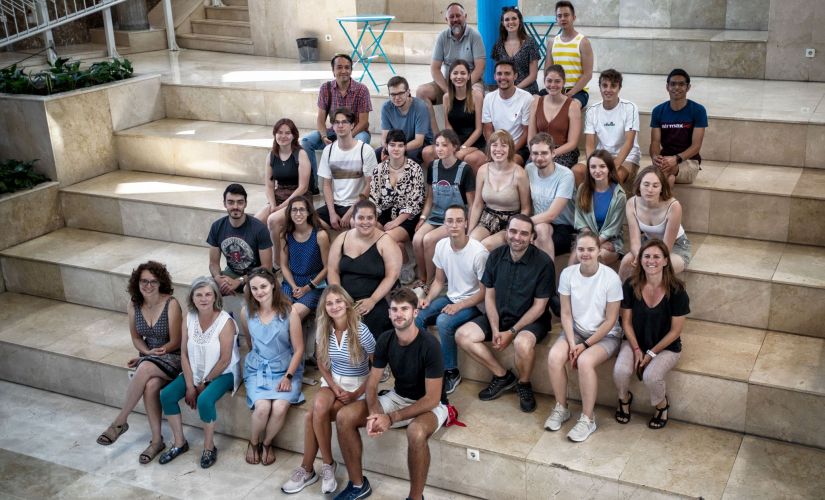 Zdjęcie pozowane: uczestnicy szkoły letniej w Vigo siedzą na schodach.