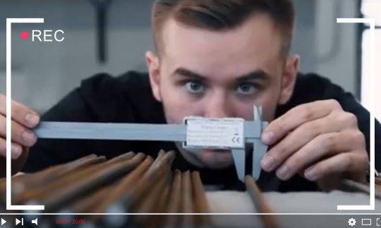 Kadr z filmu promocyjnego: student mierzący minimetrówką brązowy element.