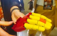 Żółto-czerwona ręka robota koła UbiComp i .Net na stoisku Women in Tech Summit 2022