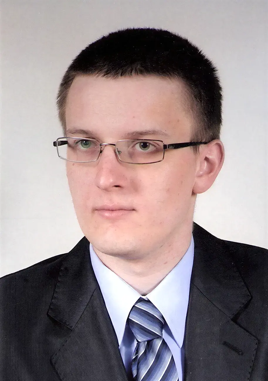 legitymacyjne zdjęcie młodego mężczyzny w okularach, garniturze, z lewego profila