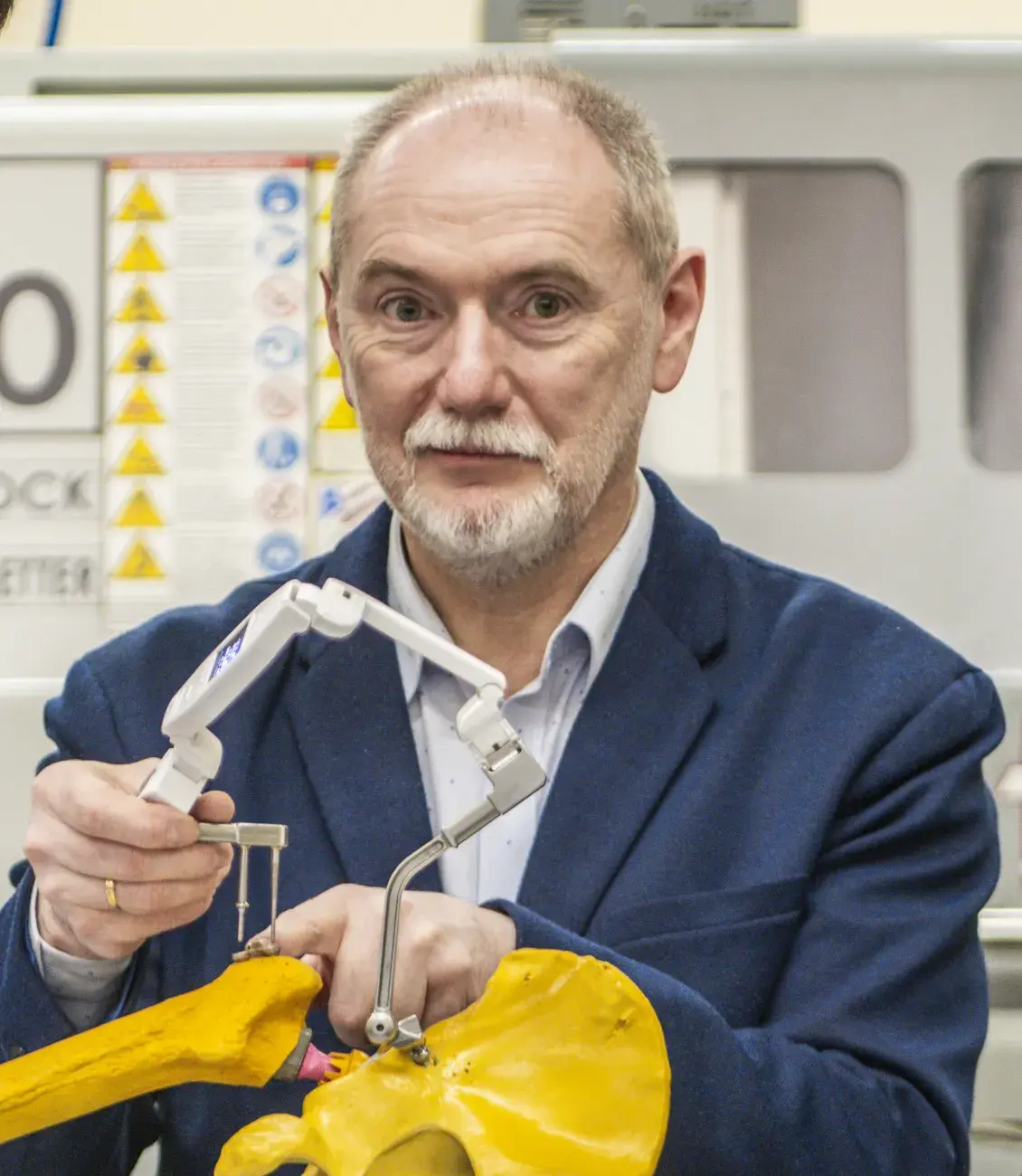 prof. leszek podsędkowski patrzy do obiektywu, trzymając w rękach prototyp ptrotezy biodra