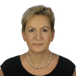 Zdjęcie portretowe: prof. Katarzyna Grabowska w ciemnej sukience i perłowym naszyjnikiem na białym tle.