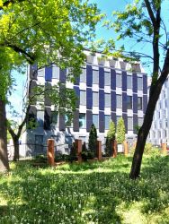 Frontowa ściana budynku pasywnego PŁ wśród zieleni.