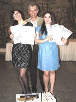 Trzy osoby: Patrycja Pałągiewicz i Marta Wróbel trzymają w rękach dyplomu, w środku uśmiechnięty mężczyzna.