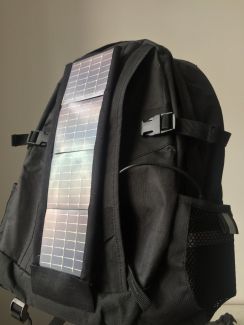 Czarny plecak z wszytymi elastycznymi ogniwami fotowoltaicznymi.