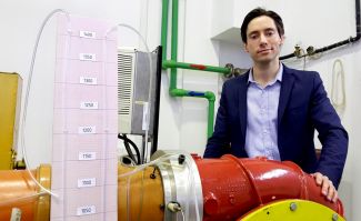 Portrait photo: Dr Eng Grzegorz Liśkiewicz in his jacket is standing in a laboratory.