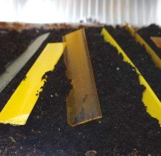 Biodegradowalny, czarny kompozyt polimerowy z plastikowymi linijkami w kolorze żółtym.