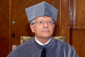 Portrait photo: Prof. Erick Vandamme in grey gown at the ceremony of awarding the DHC title of TUL.