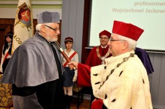 Prof. Stanisław Bielecki, TUL rector, in red gown and white ermine is resting a scepter on the shoulder of Prof. Wojciech Jacek Stec in grey gown and is awarding him the DHC title of TUL.