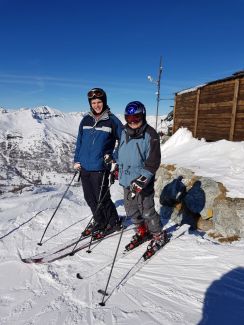 Prof. Andrzej Napieralski z synem stoją w strojach narciarskich i nartach. W tle zimowy pejzaż.