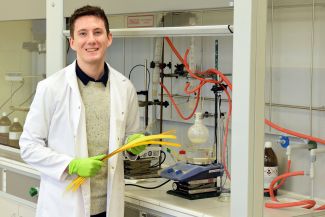 Stefan Cichosz in a white lab coat next to laboratory apparatus.