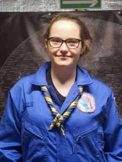 Portrait photo: Aleksandra Wilczyńska, a TUL student, wearing a blue jacket against a dark background.