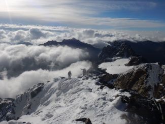 Widok z wysokich gór pokrytych śniegiem, chmur i błękitnego nieba - podejścia na Margherita Peak.