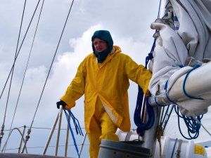 prof. J.Wojewoda w żółtym stroju przeciwdeszczowym na łodzi. Na horyzoncie sztormowe chmury.