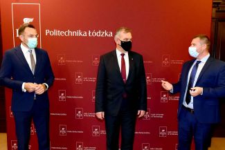 Standing against a maroon wall with TUL logotypes are (from left): the President of the Board of the TUL Foundation, the Rector of TUL and a representative of Santander