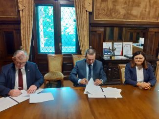 In the Rector's office, at a wooden table, the Rector of Lodz University of Technology Krzysztof Jóźwik, the Director of the Szamotuły Hospital Remigiusz Pawelczyk and Beata Hanyżak, the Starost of Szamotuły sit and sign documents.