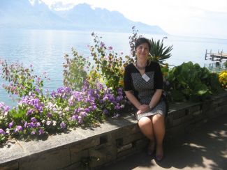 prof. Dorota Kręgiel siedzi na tle jeziora i roślinności