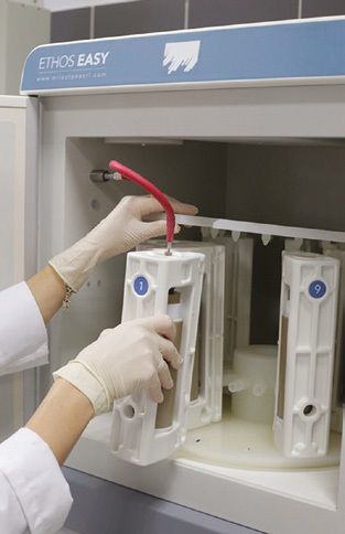 prOverview photo: a piece of equipment with the door open and two gloved hands inserting the white piece inside.