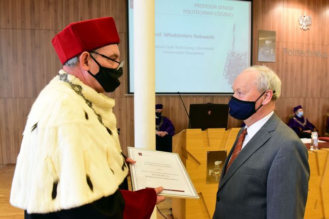 Po lewej stronie prof. Krzysztof Jóźwik w todze, rektor PŁ wręcza pamiątkowy dyplom prof. Włodzimierzowi Nakwaskiemu, który stoi po prawej stronie.