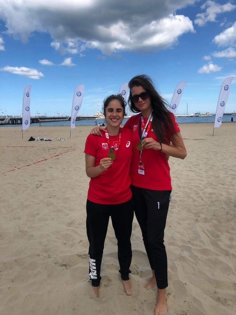  Claudia Cova i Malwina Schonhofer na plaży prezentują medale.