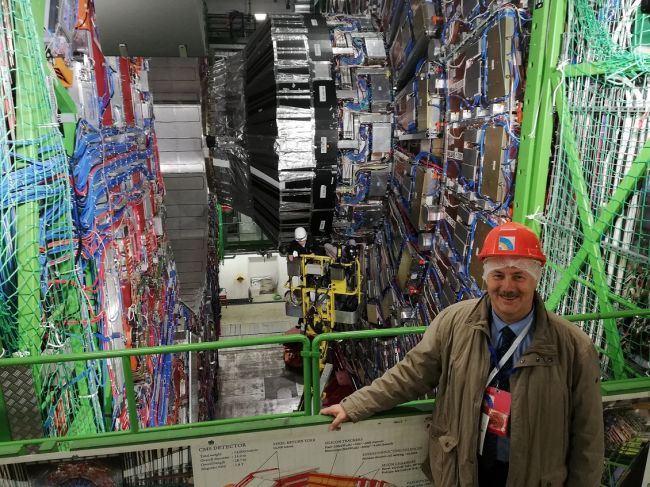 Prof. Piotr Borkowski w CERN, na tle detektora cząstek elementarnych CMS, Wielkiego Zderzacza Hadronów