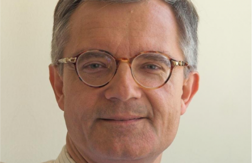 Zdjęcie portretowe: prof. Andrzej Bartoszewicz w białej koszuli na jasnym tle.