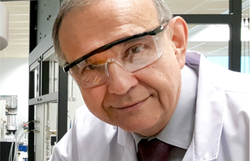 Zdjęcie portretowe: Prof. Andrzej Górak w białym fartuchu i okularach ochronnych w laboratorium.