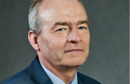 Zdjęci portretowe: prof. dr hab. inż. Dariusz Gawin w ciemnym garniturze, niebieskiej koszuli i krawacie na szarym tle.