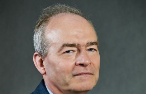 Zdjęci portretowe: prof. dr hab. inż. Dariusz Gawin w ciemnym garniturze, niebieskiej koszuli i krawacie na szarym tle.