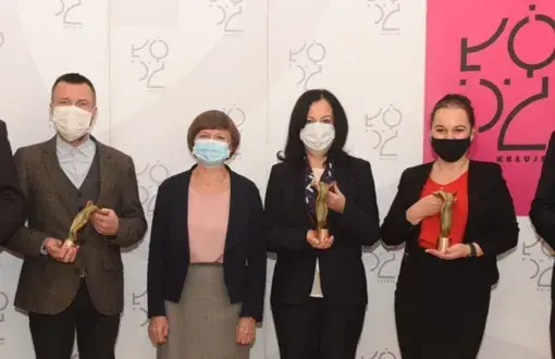 Pięcioro laureatów konkursu UMŁ w wiceprezydentem Łodzi. W tle szara ścianka z logiem Łodzi.