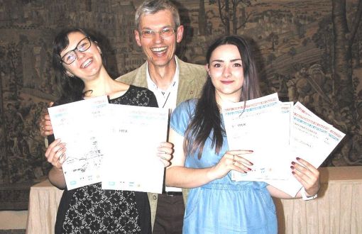 Trzy osoby: Patrycja Pałągiewicz i Marta Wróbel trzymają w rękach dyplomu, w środku uśmiechnięty mężczyzna.