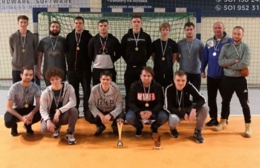 12 studentów z sekcji piłki ręcznej, pozuje w dwóch rzędach do zdjęcia. Z boku dwóch  trenerów.