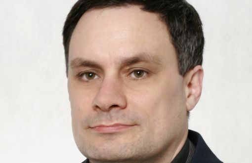 Zdjęcie portretowe: dr hab. inż. Michał Kaczmarek, prof. PŁ w czarnej marynarce i ciemnej koszuli na jasnym tle.
