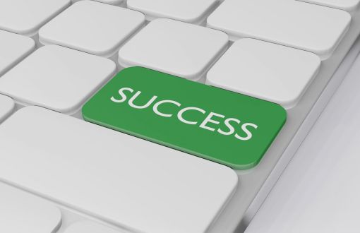 Fragment białej klawiatury komputerowej. Jeden z klawiszy jest zielony z białym napisem Success.