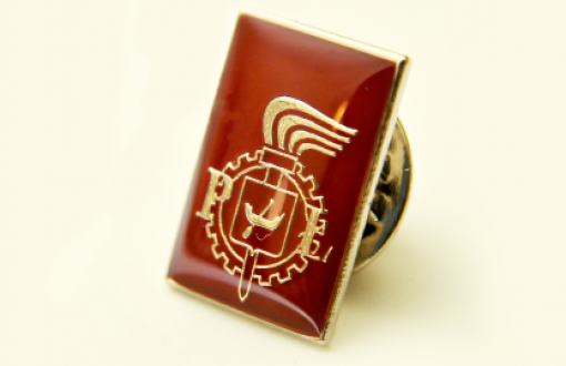 Rectangular corporate badge with the logo of Lodz University of Technology on a maroon background on a light background.
