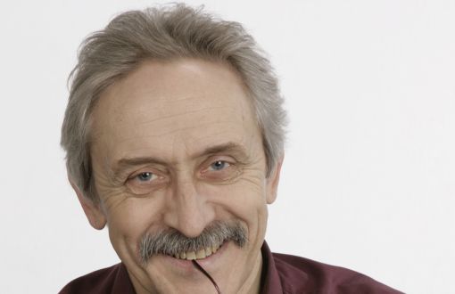 Zdjęcie portretowe: prof. Krzysztof Wojciechowski w bordowej koszuli na jasnym tle.