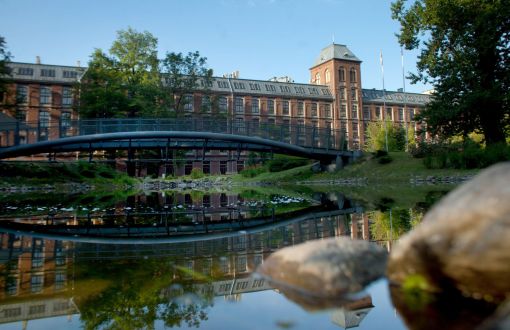 Kampus B Politechniki Łódzkiej: staw, mostek, w tle ceglany Budynek Trzech Wydziałów.