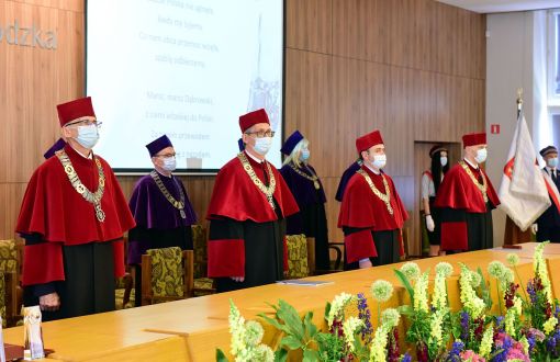 Uroczyste posiedzenie Senatu PŁ z okazji 76. rocznicy powstania uczelni. Na pierwszym planie czterej prorektorzy w czerwonych togach, w tle dziekani w szarych togach. Po prawej stronie poczet sztandarowy.