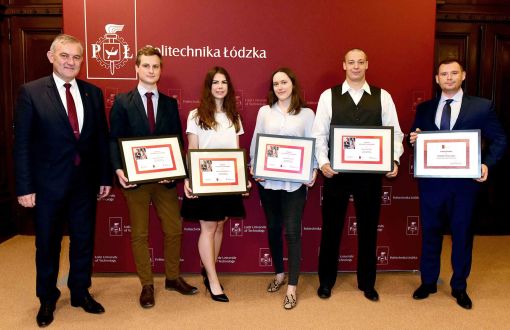 Pięciu, elegancko ubranych laureatów stypendiów Santandera prezentuje symboliczne dyplomy. Pierwszy z lewej JM Rektor PŁ, prof. Krzysztof Jóźwik. W tle bordowa ścianka z białym logotypem Politechniki Łódzkiej.
