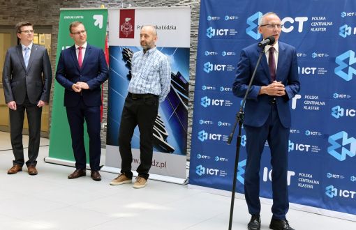 prof. Paweł Strumiłło na tle niebieskiej ścianki z logami ICT Polska Centralna Klaster podczas oficjalnego otwarcia nowego cyklu edukacyjnego, fot. arch. PŁ