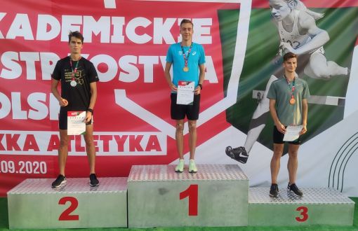 Zwycięzcy biegu na 400 m stoją w strojach sportowych na podium: na szyjach mają medale, w dłoniach trzymają pamiątkowe dyplomy. W środku, na najwyższym podium Mateusz Rzeźniczak, po lewej Kajetan Duszyński.