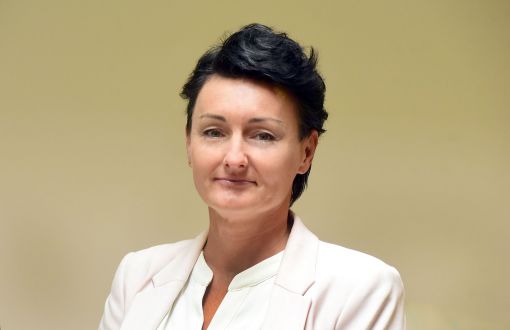 Zdjęcie portretowe: dr Ewa Brochocka w białej marynarce i koszuli na jasnym tle.