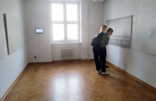Duże, jasne pomieszczenie. Studenci oglądają wystawę: Punkt, Linia, Płaszczyzna.