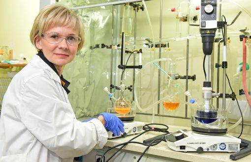 Prof. Joanna Pietrasik z Wydziału Chemicznego PŁ w białym fartuchu przy stanowisku laboratoryjnym.