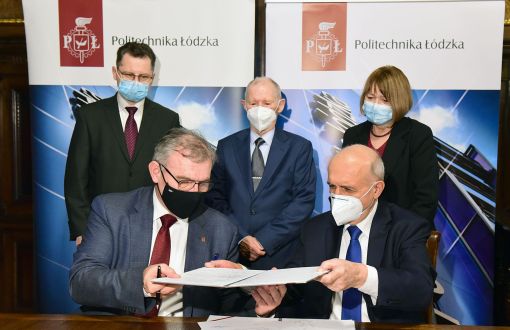 Rektor prof. Krzysztof Jóźwik i prezes Włodzimierz Kęsicki wymieniają się podpisaną umową. W drugim rzędzie stoją - dyrektor techniczny firmy Piotr Nowakowski, prof. Sławomir Wiak dyrektor Instytutu Mechatroniki i Systemów Informatycznych (IMSI), prof. Maria Dems, zastępca dyrektora IMSI.