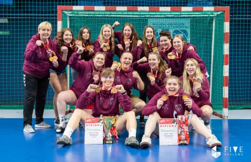 Zdjęcie grupowe: szczypiornistki PŁ na AMP w piłce ręcznej na tle bramki.